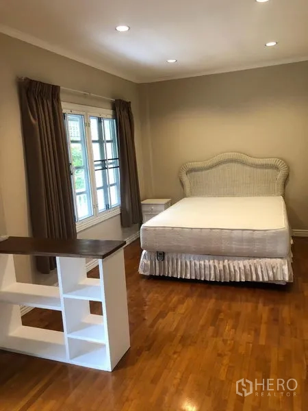 ทาวน์เฮาส์ ให้เช่าในMueang Samut Prakan, Samut Prakan - ห้องนอนพร้อมเตียง โต๊ะหัวเตียง หน้าต่างบานใหญ่พร้อมผ้าม่าน ไฟดาวน์ไลท์ และพื้นไม้โทนอุ่น