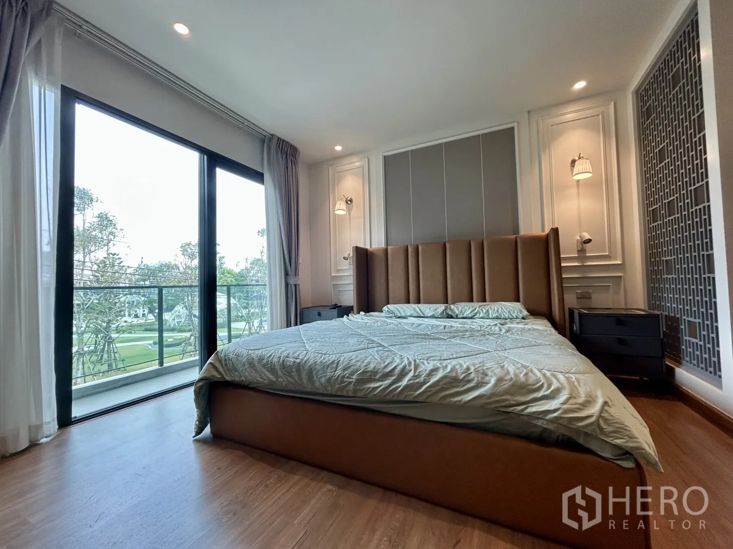 Detached House for rent in Bang Phli, Samut Prakan - Bedroom with upholstered bed and balcony overlooking green park.
