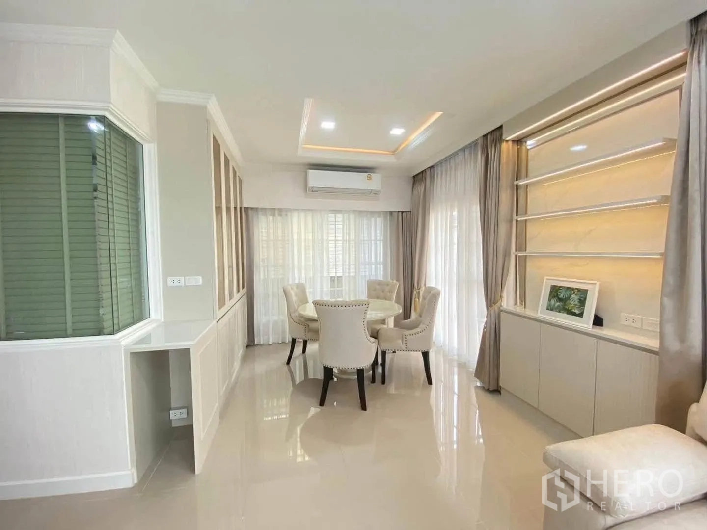 Detached House for rent in Mueang Samut Prakan, Samut Prakan - Dining area with round table, built-in storage, and large windows.