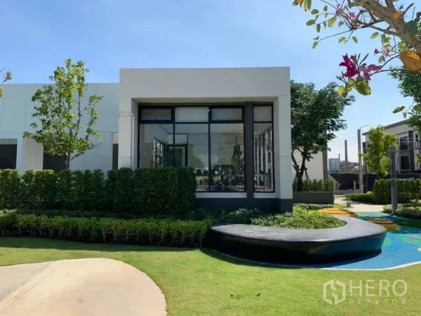 Townhouse for rent or sale in Phasi Charoen, Bangkok - Community clubhouse with floor-to-ceiling glass and landscaped gardens.