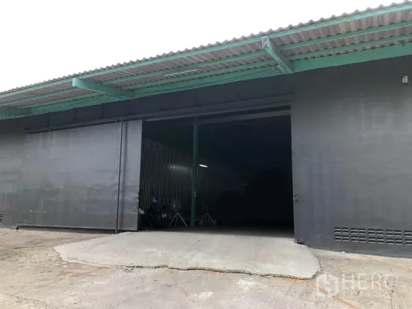 货栈 出租在Khan Na Yao, Bangkok - 入口装卸坡道与大型推拉门，外伸雨棚覆盖。