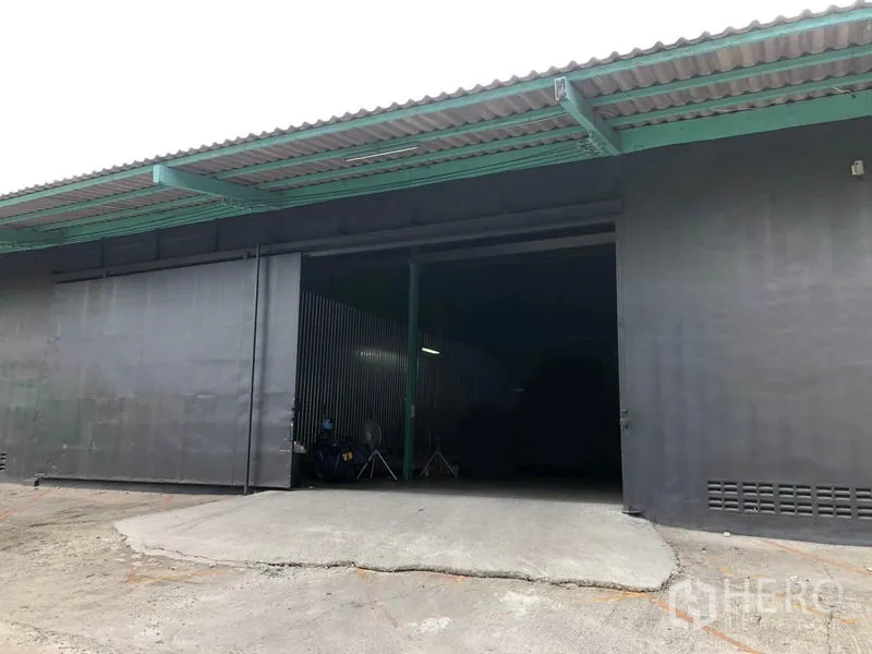 货栈 出租在Khan Na Yao, Bangkok - 入口装卸坡道与大型推拉门，外伸雨棚覆盖。