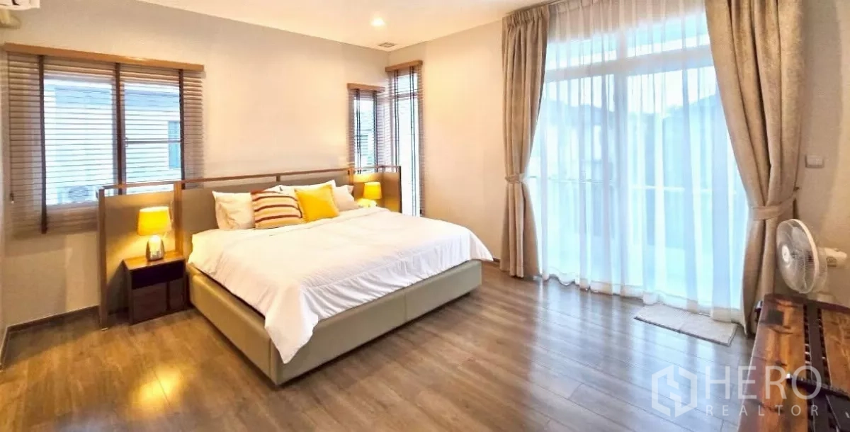 Detached House for rent in Samut Prakan - Spacious master bedroom with king bed and floor-to-ceiling windows.