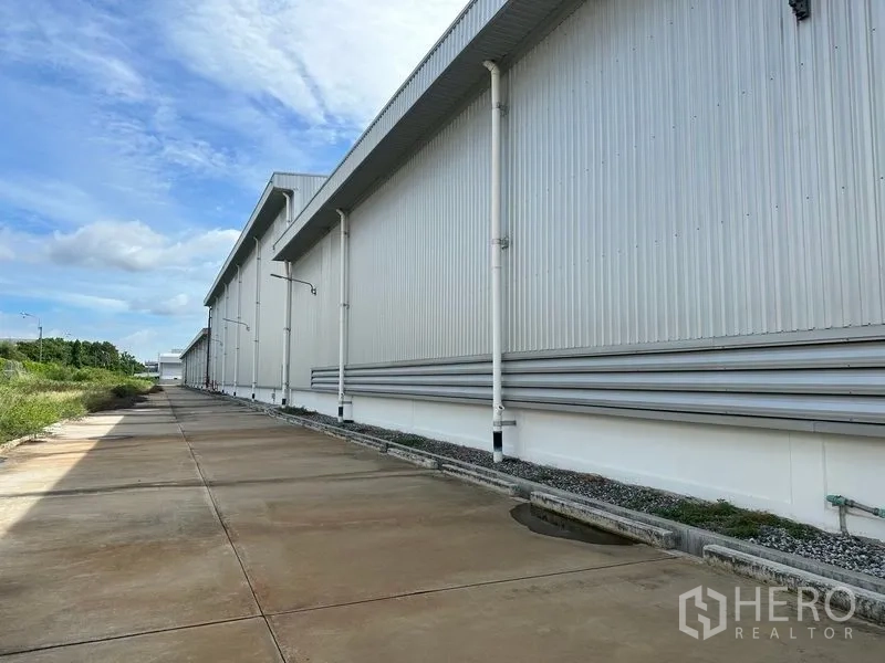 工厂 出租在Bang Sao Thong, Samut Prakan - 金属夹芯板外墙一侧的服务通道，带排水沟