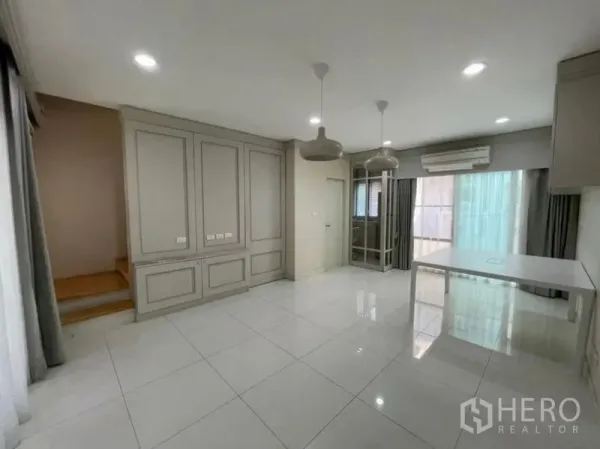 ทาวน์เฮาส์ ขาย - โซนนั่งเล่น–รับประทานอาหารชั้นล่าง มีบันได แอร์ และประตูกระจกบานเลื่อนไปยังชานบ้าน