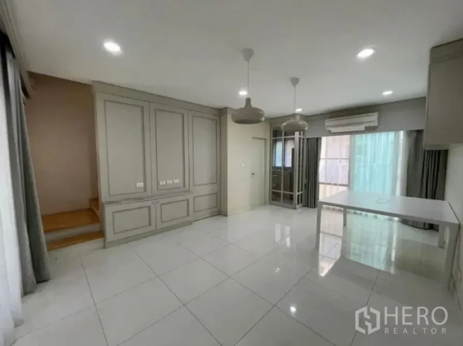 ทาวน์เฮาส์ ขาย - โซนนั่งเล่น–รับประทานอาหารชั้นล่าง มีบันได แอร์ และประตูกระจกบานเลื่อนไปยังชานบ้าน