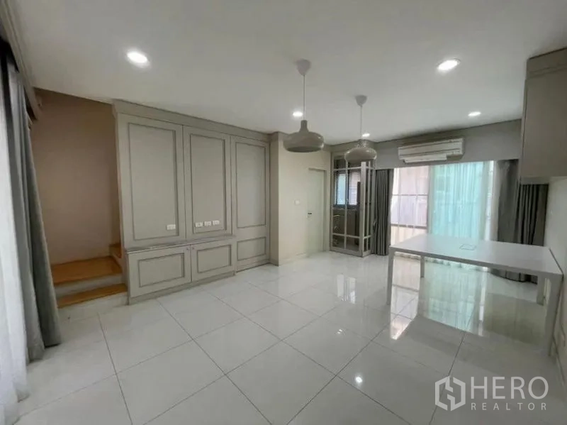 ทาวน์เฮาส์ ขาย - โซนนั่งเล่น–รับประทานอาหารชั้นล่าง มีบันได แอร์ และประตูกระจกบานเลื่อนไปยังชานบ้าน