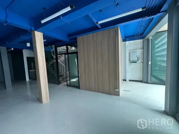 办公空间 出租在Watthana, Bangkok - 带玻璃入口的办公区，木质隔间与室内楼梯，采光充足。