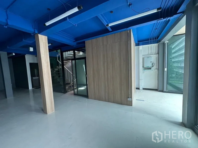 办公空间 出租在Watthana, Bangkok - 带玻璃入口的办公区，木质隔间与室内楼梯，采光充足。