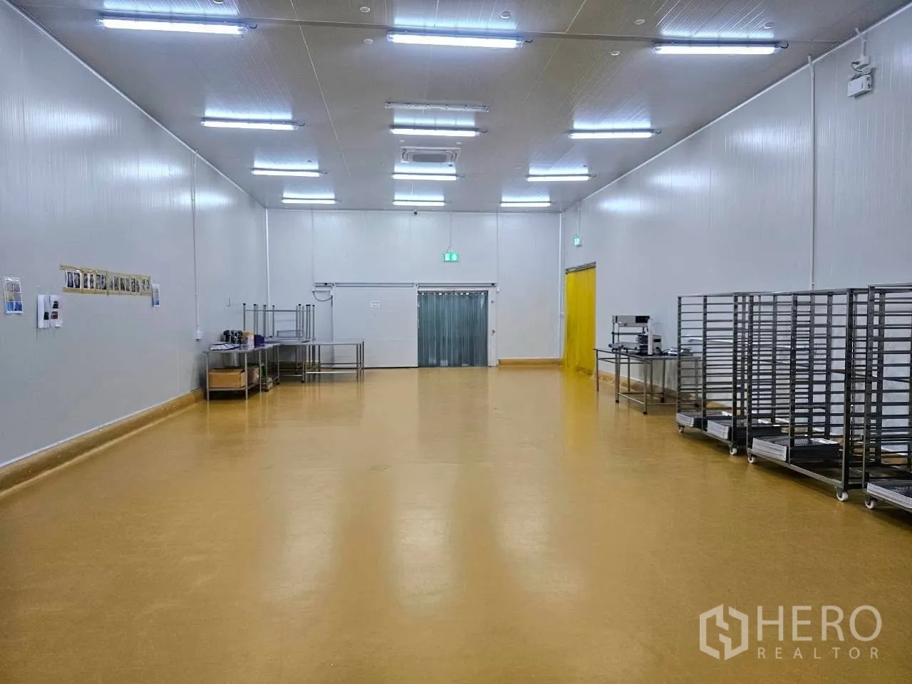 工厂 for rent in Mueang Samut Sakhon, Samut Sakhon - 生产间，黄色地坪配不锈钢置物架与工位。