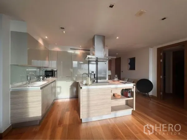 คอนโด ให้เช่าหรือขายในPhaya Thai, Bangkok - ครัวแบบเปิดพร้อมไอส์แลนด์ เครื่องดูดควันสแตนเลส ตู้บิลท์อิน และพื้นไม้โทนอุ่นในคอนโดสมัยใหม่