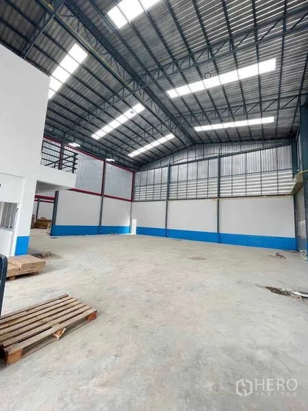 Warehouse for rent in Bang Phli, Samut Prakan - High-bay warehouse floor with natural light roof panels and attached office block.