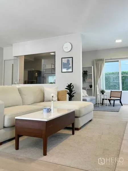 บ้าน ให้เช่าหรือขายในPrawet, Bangkok - ห้องนั่งเล่นโปร่งโล่ง โซฟาเข้ามุม โต๊ะกลาง หน้าต่างบานใหญ่ พื้นไม้สีอ่อน