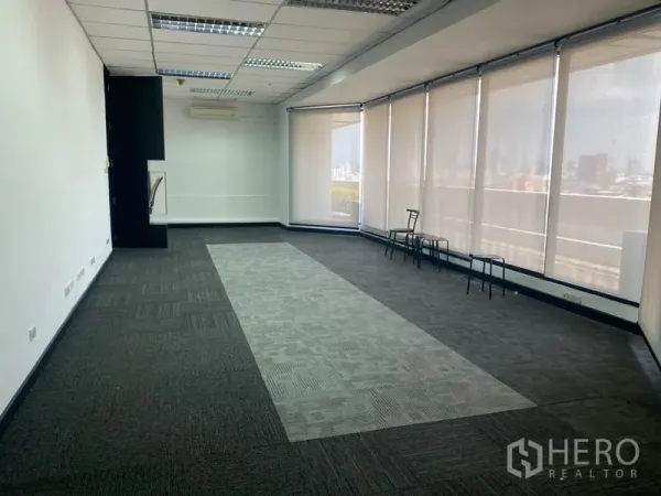 办公空间 出租在Din Daeng, Bangkok - 开放式办公区，地毯方块，落地窗配卷帘，曼谷天际线景观。