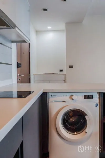 公寓 出租在Khlong Toei, Bangkok - 四人餐桌对着大镜面，旁连客厅与卫生间门。