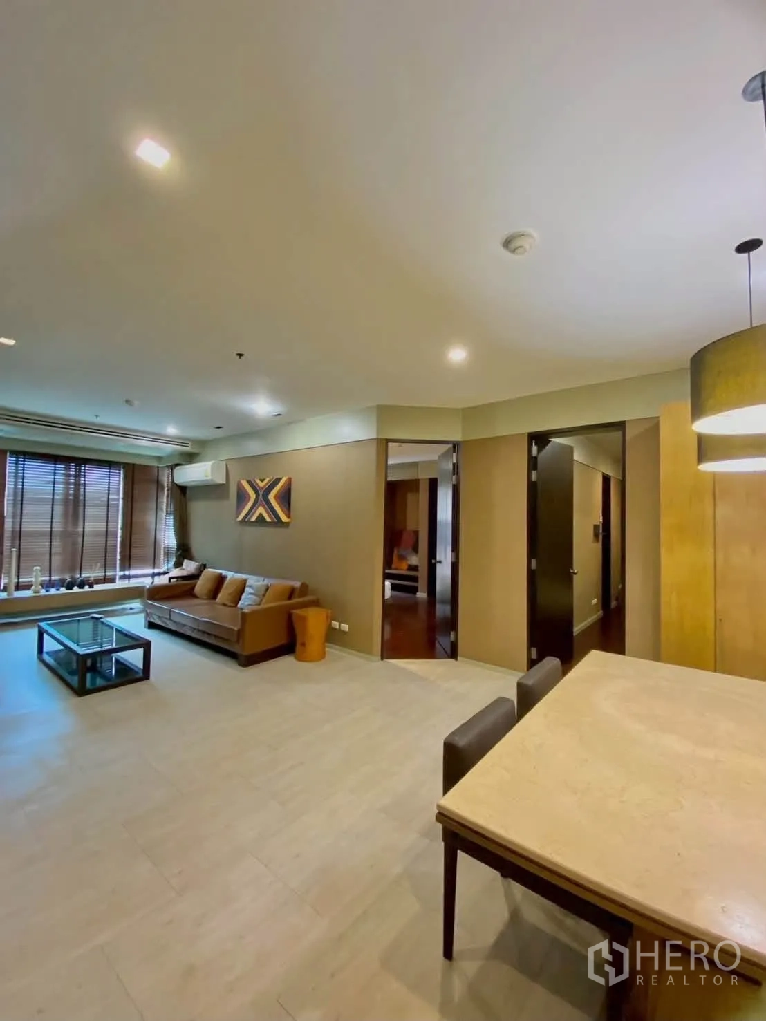 公寓 for rent in Khlong Toei, Bangkok - 宽阔视角的客餐一体空间，大窗与暖色装饰。