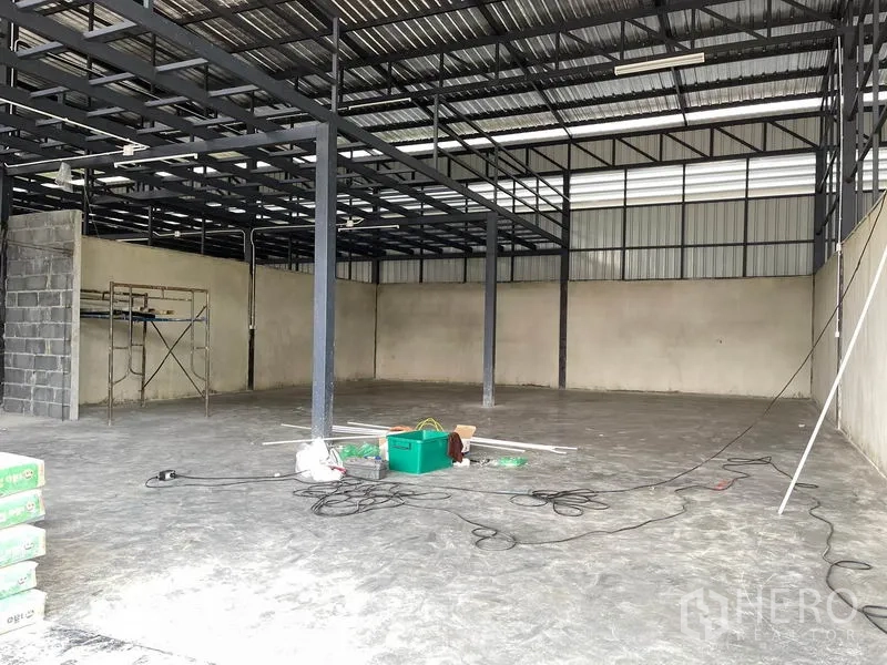 货栈 出租在Pathum Thani - 明亮内部，钢梁网架、脚手架与平整混凝土地面。