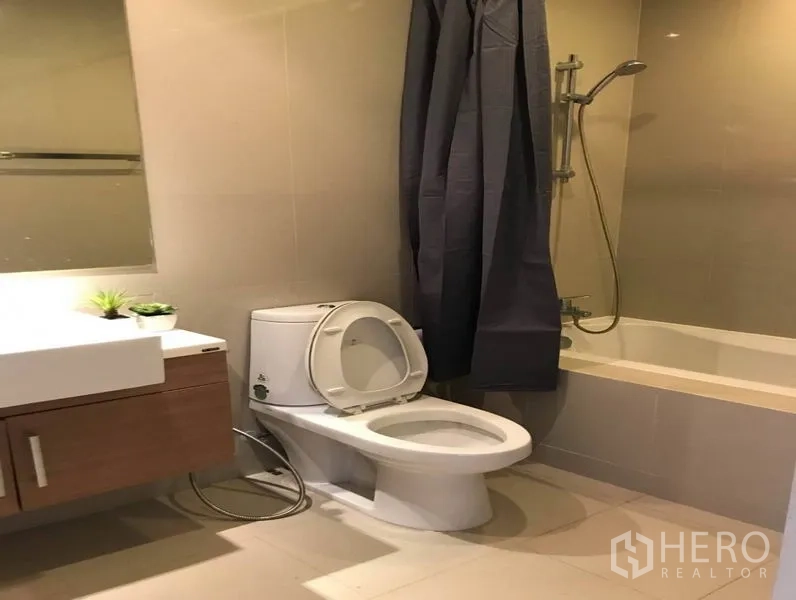 คอนโด ให้เช่าในBangkok - ห้องน้ำโทนสีอบอุ่นพร้อมอ่างอาบน้ำ ฝักบัว อ่างล้างหน้า และโถสุขภัณฑ์