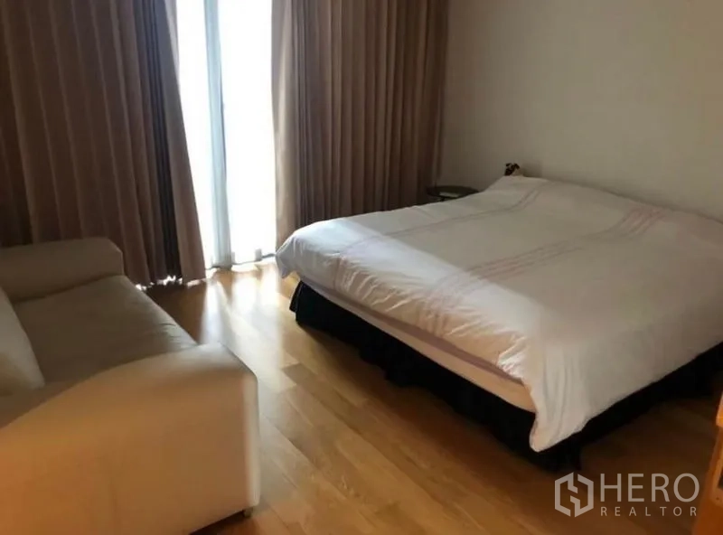 คอนโด ให้เช่าในSathon, Bangkok - ห้องนอนอบอุ่น พื้นไม้ โซฟา และประตูกระจกพร้อมผ้าม่าน