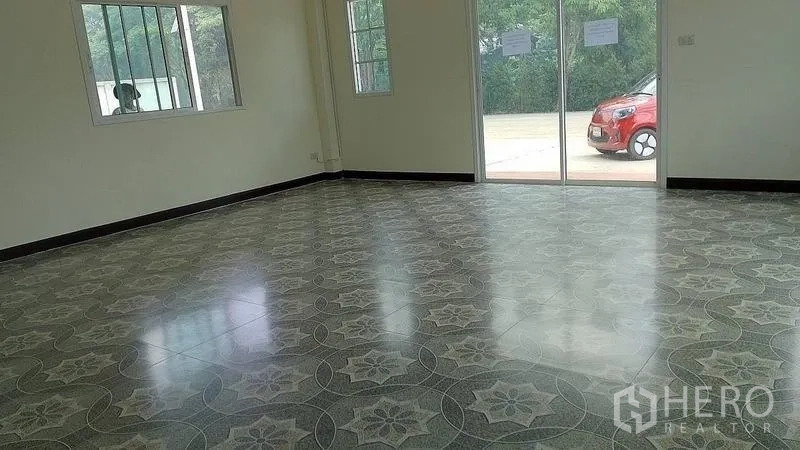 Warehouse for rent or sale in Nakhon Pathom - Ground-floor office or showroom with patterned tiles and sliding glass doors opening to the parking area.