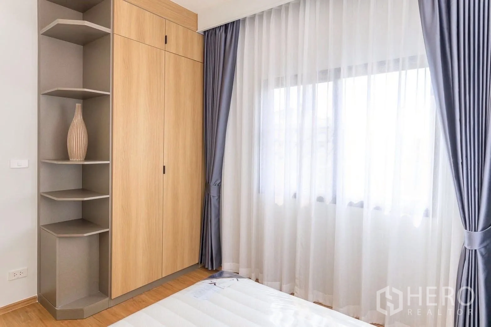 Townhouse for rent or sale in Bang Phli, Samut Prakan - Built-in wardrobe with open display shelves beside a window with layered curtains.
