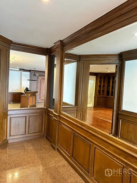 คอนโด ให้เช่าในBangkok - โถงทางเดินกรุไม้ติดกระจกเงามองไปยังพื้นที่นั่งเล่น