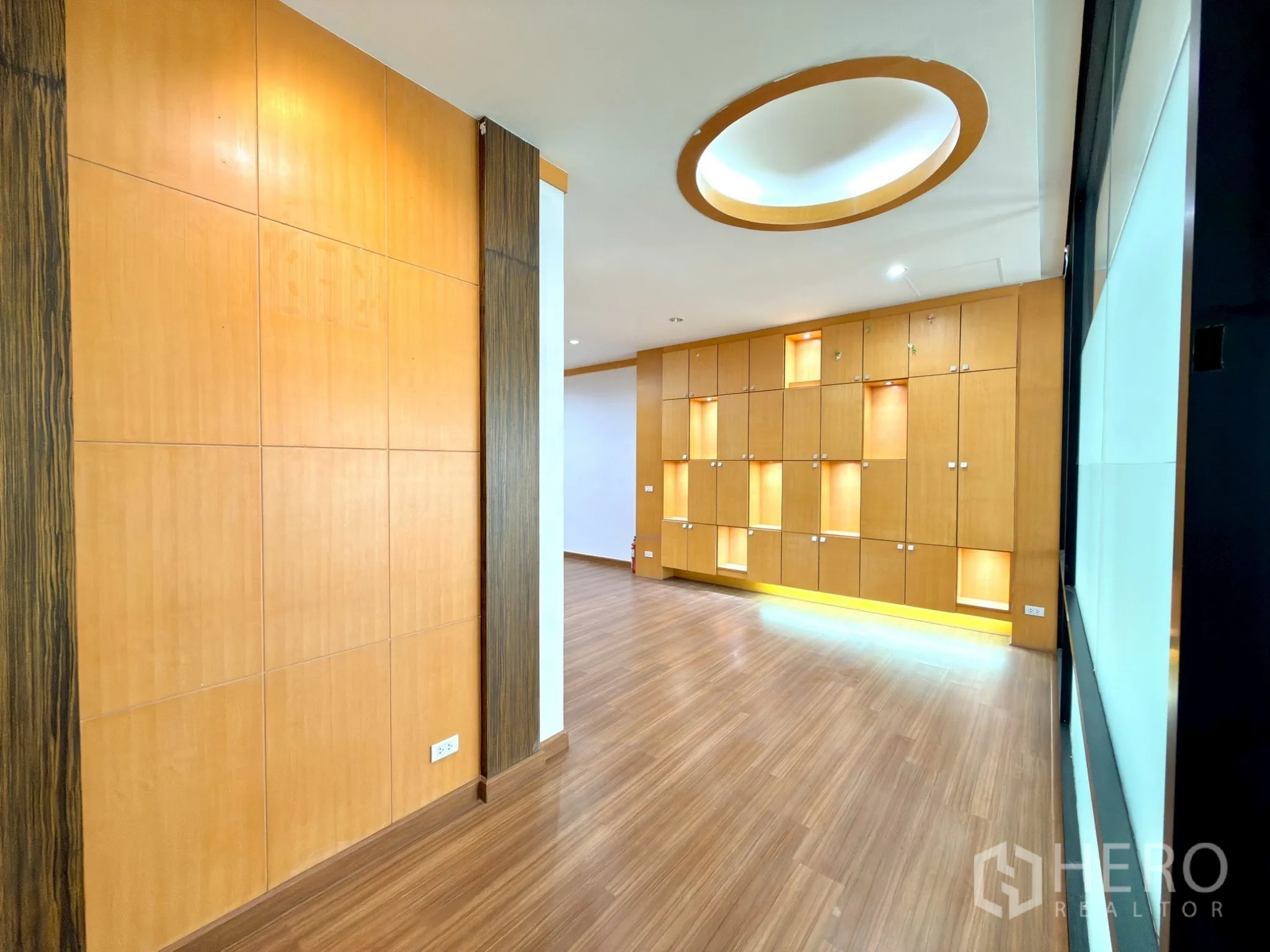 Office Space for rent in Watthana, Bangkok - Entry area with circular ceiling detail and illuminated display cabinets along the wall.