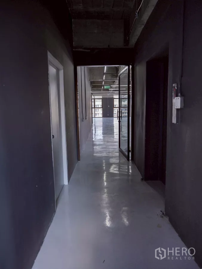 Office Space for rent - Dark hallway leading to a bright open-plan office with LED strip lights.