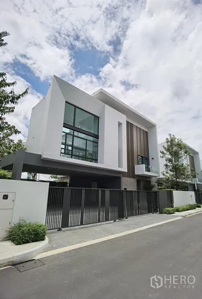 Detached House for rent or sale in Saphan Sung, Bangkok - Modern detached house exterior repeat view with cantilevered roof and metal fence.