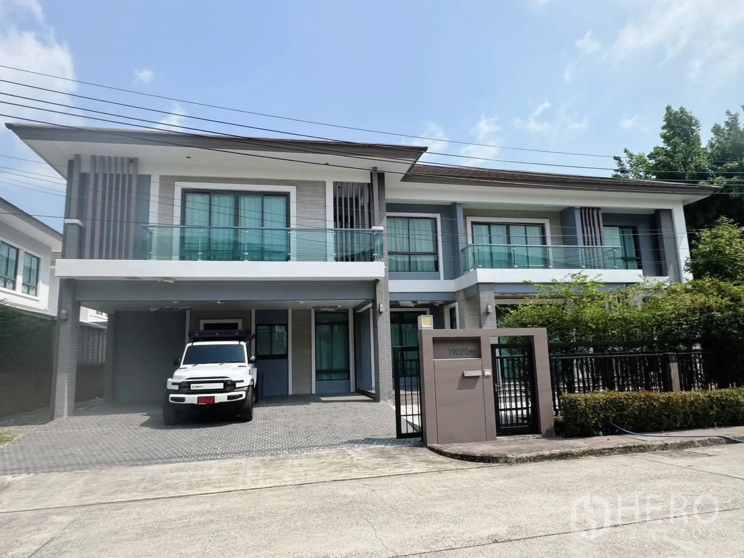 Detached House for rent or sale in Suan Luang, Bangkok - Modern two-storey house exterior with balconies, carport and gate.