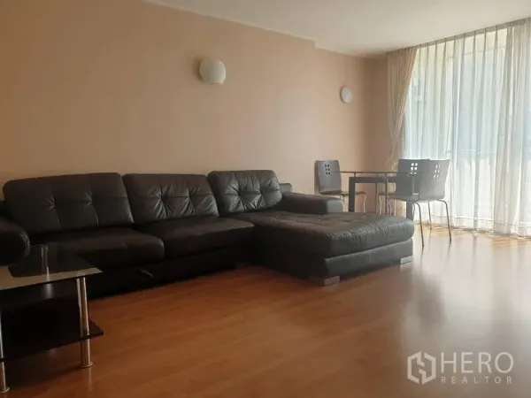 คอนโด ให้เช่าหรือขายในWatthana, Bangkok - ห้องนั่งเล่นสว่าง โซฟาหนังสีดำ มุมทานอาหาร และหน้าต่างสูงจรดเพดาน