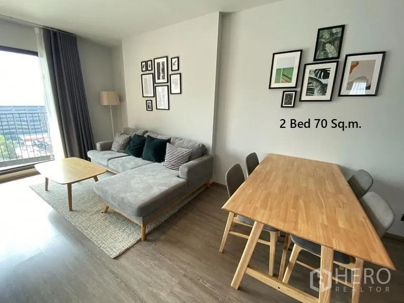 Condominium for rent in Watthana, Bangkok - Living area with L-shaped sofa, four-seat dining table and balcony outlook in Watthana condo.