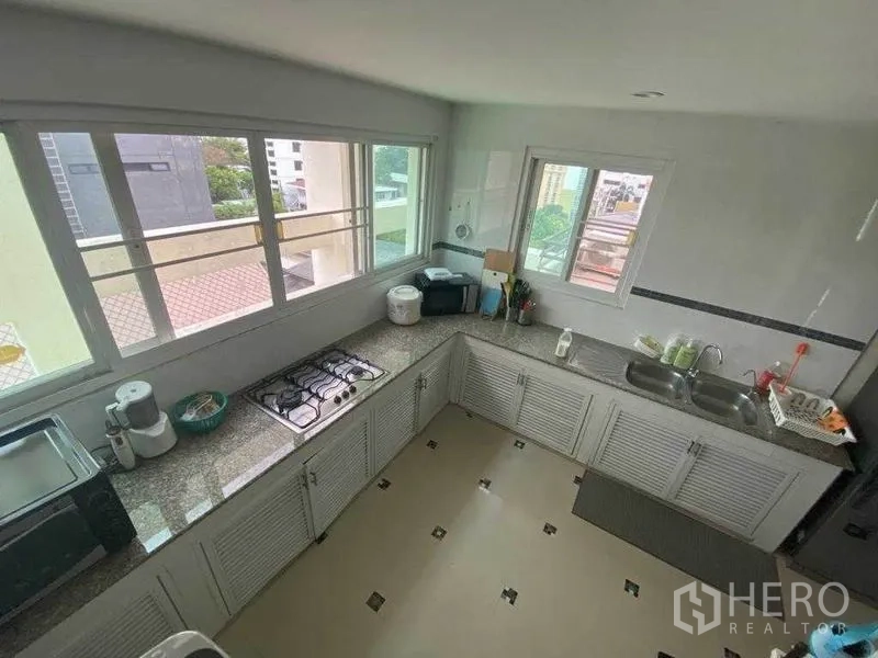 คอนโด ให้เช่าในWatthana, Bangkok - ภาพมุมสูงของครัวปิดรูปตัวแอล หน้าต่างบานใหญ่ เคาน์เตอร์แกรนิต และเครื่องใช้ไฟฟ้า