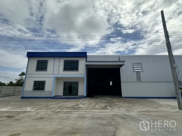 工厂 出租或出售在Sai Noi, Nonthaburi - 工厂正门外观，带高位装卸口与大型卷门，旁为办公楼。