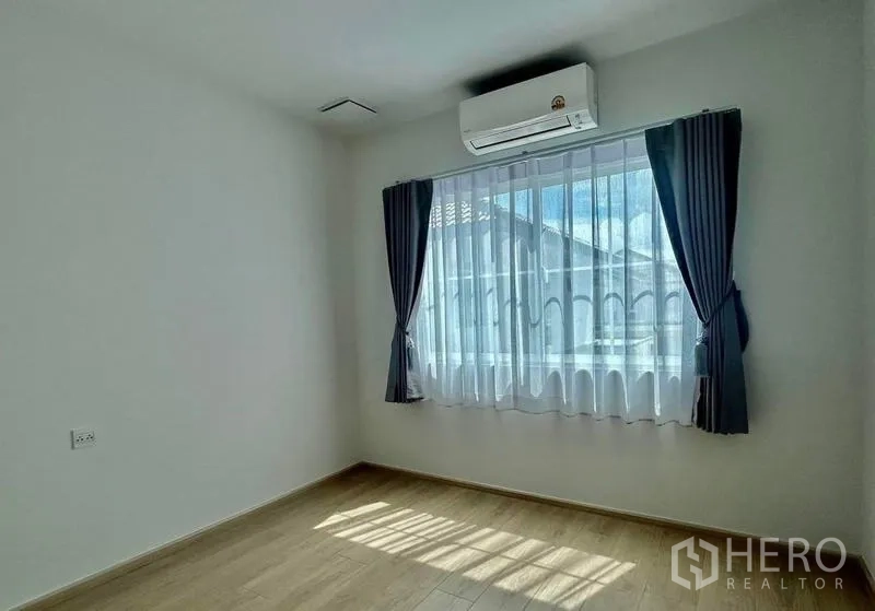 Townhouse for rent in Bang Phli, Samut Prakan - Cozy secondary bedroom with window, blackout curtains and air conditioner.
