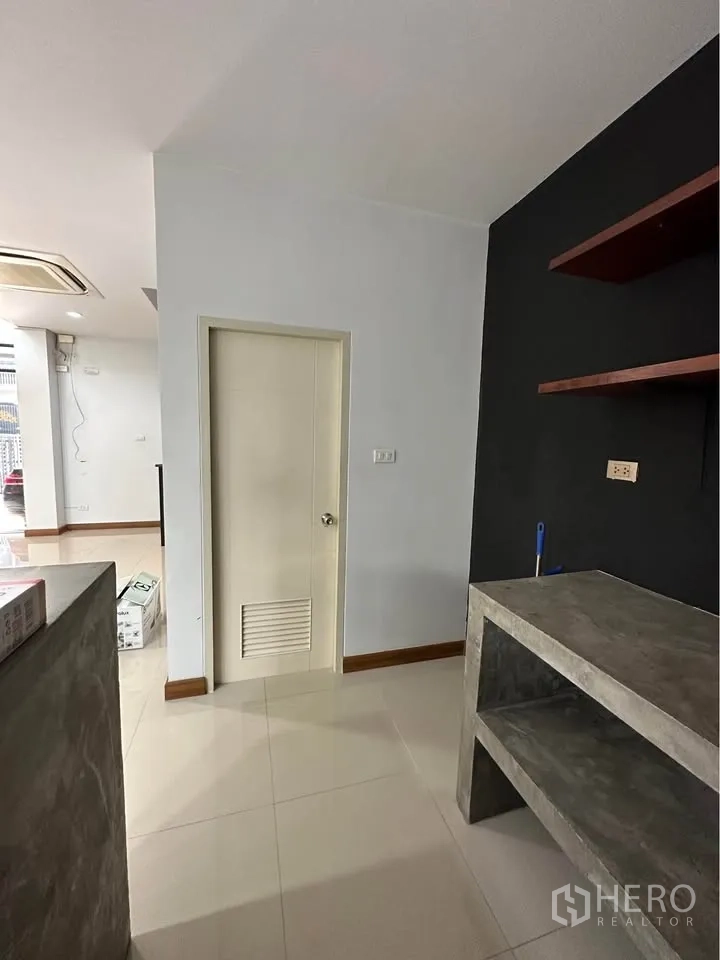 Townhouse for rent in Pak Kret, Nonthaburi - Ground-floor pantry corner with concrete shelves and storage door.