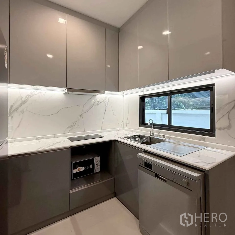 Detached House for rent in Bang Phli, Samut Prakan - Modern U-shaped kitchen with marble backsplash, sink, cooktop and dishwasher.