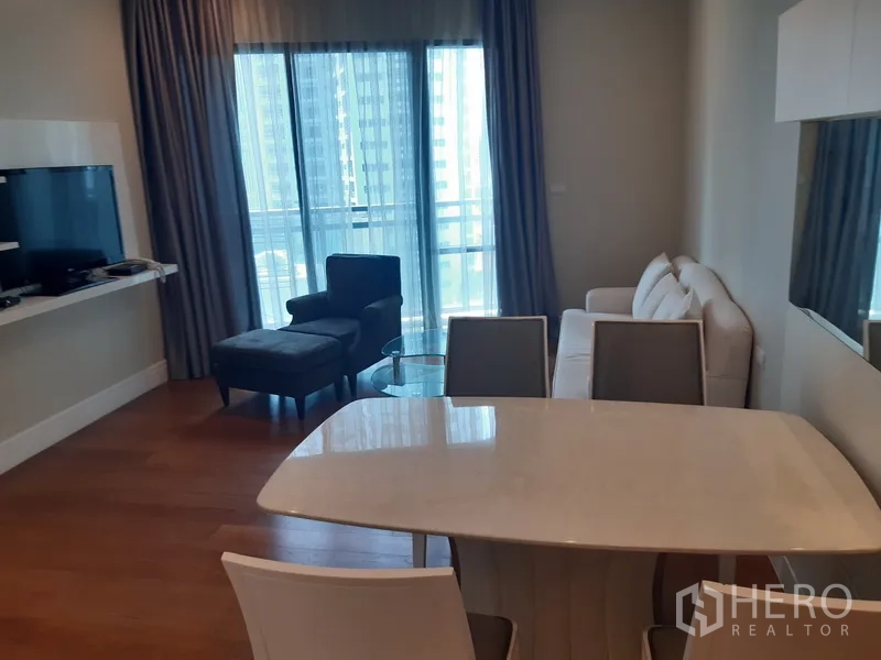 คอนโด ให้เช่าในKhlong Toei, Bangkok - ห้องนั่งเล่นและทานอาหารสว่าง โต๊ะท็อปหินอ่อน โซฟา ทีวี พร้อมประตูระเบียงและวิวเมือง