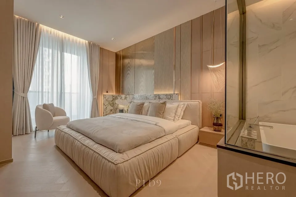 คอนโด for rent in Sathon, Bangkok - ห้องนอนหลักมีเตียงบุผ้า หน้าต่างใหญ่ และห้องน้ำกั้นกระจกพร้อมอ่างอาบน้ำ