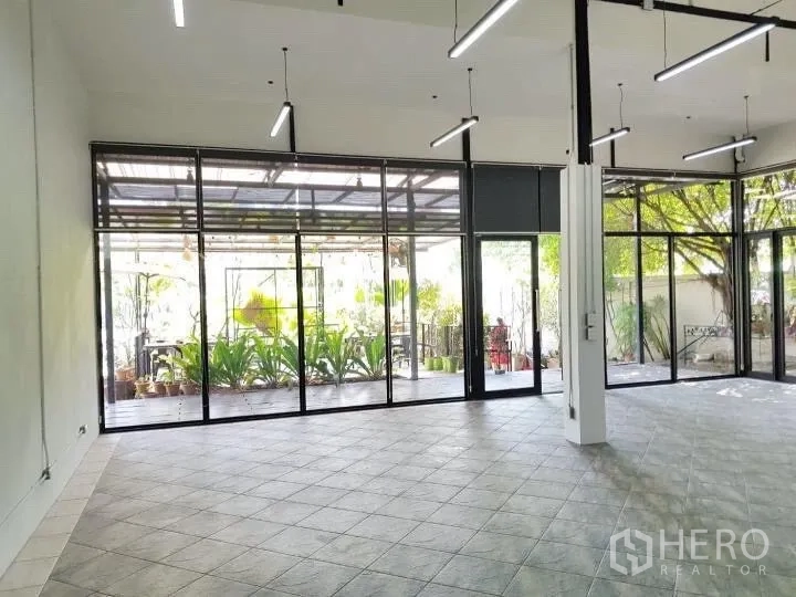 办公空间 出租在Chatuchak, Bangkok - 宽敞办公室大厅，通高窗户面向绿意庭院。