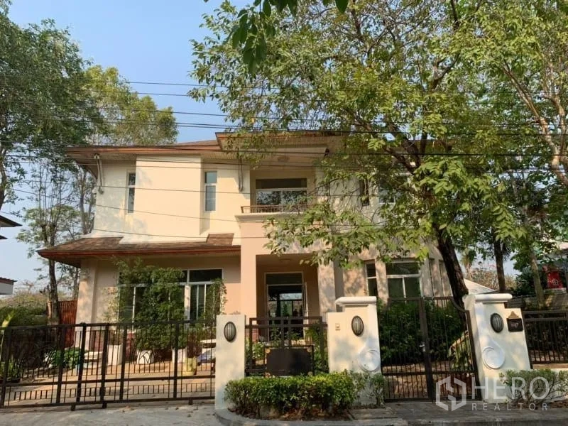 独立式住宅 出租在Lat Krabang, Bangkok - 两层独栋别墅外观，前院围栏与成树环绕。