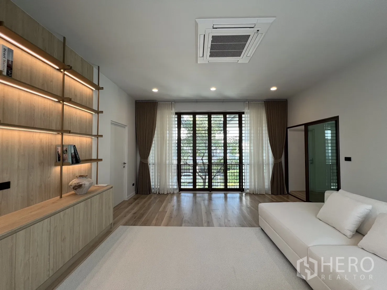 Detached House for rent or sale in Bang Kapi, Bangkok - Upper living area with large sofa, wood floors and ambient lighting.