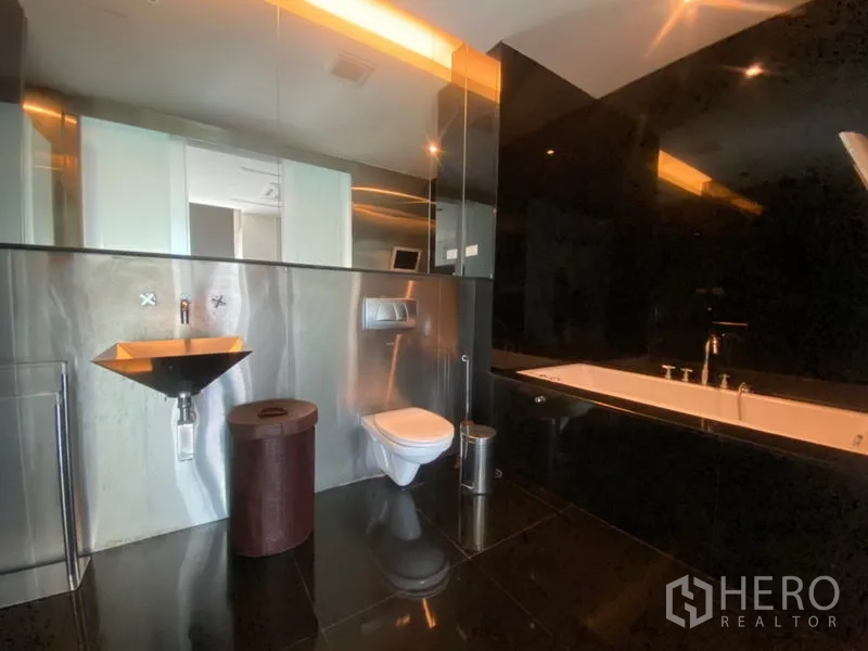 公寓 出租在Sathon, Bangkok - 奢华浴室，深浸浴缸、黑色墙面与金属质感台盆。