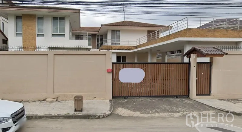 独立式住宅 出租在Prawet, Bangkok - 曼谷帕拉威区两层独栋别墅，高墙围合，木质滑动大门，带露台与有顶车位。