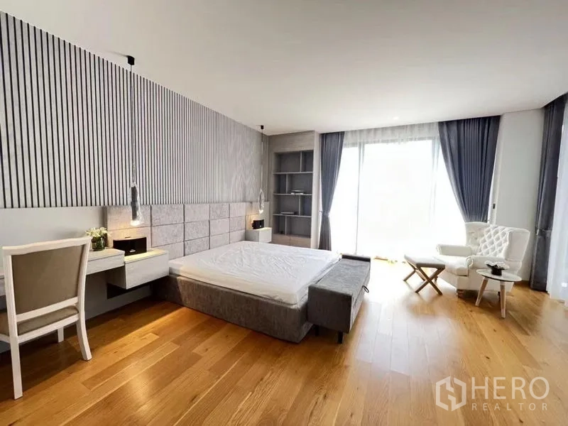 Detached House for sale in Suan Luang, Bangkok - Spacious master bedroom with wood flooring, large windows, built-in headboard and a study nook.