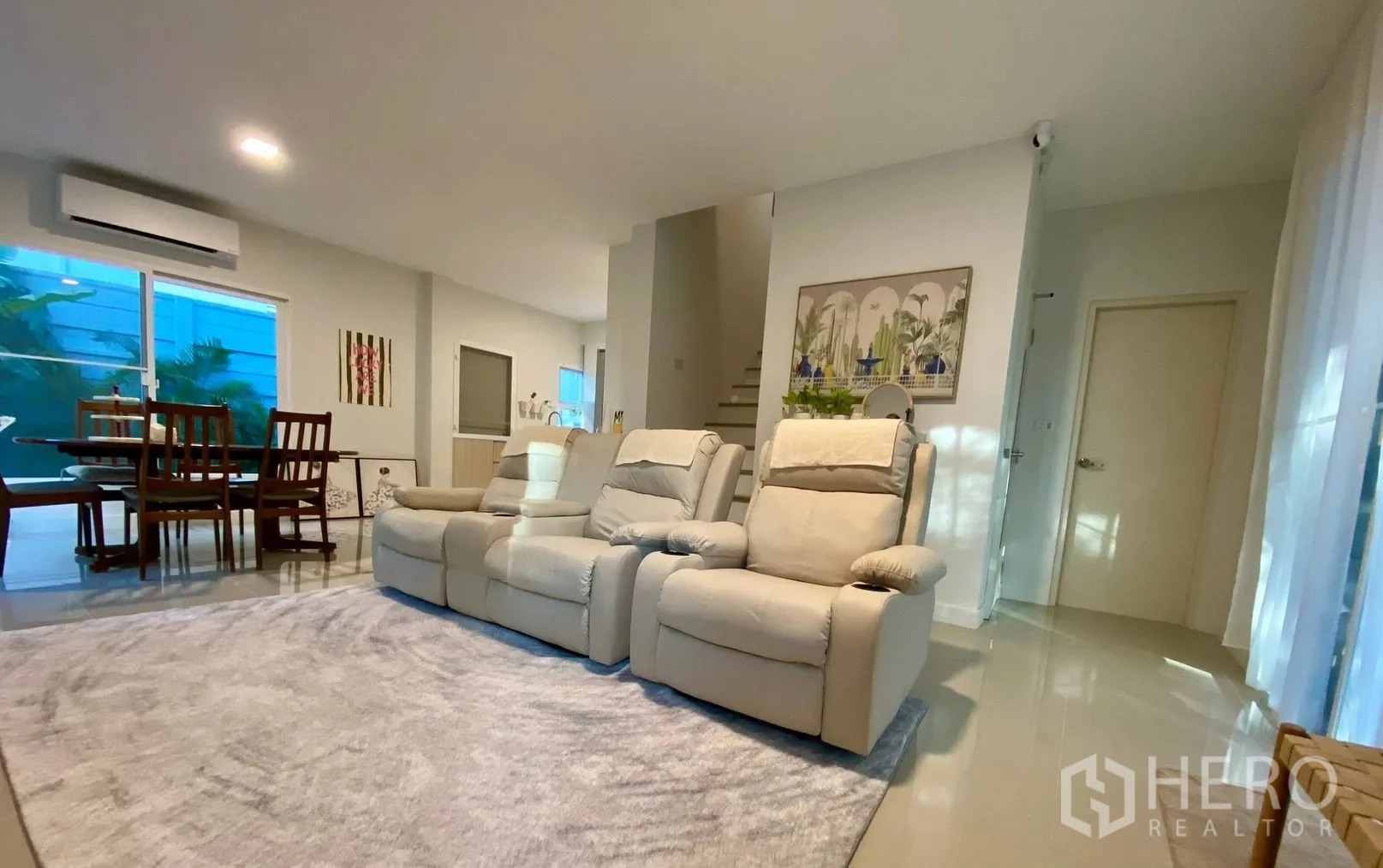 Semi-detached House for rent in Bang Phli, Samut Prakan - Open-plan living and dining area with recliner sofa and stairs in the background.