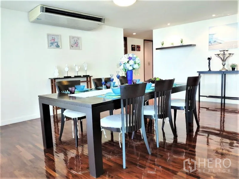 Condominium for rent in Bang Rak, Bangkok - Dining room with a six-seat table, decor shelving and air-conditioning over shiny wood floors.
