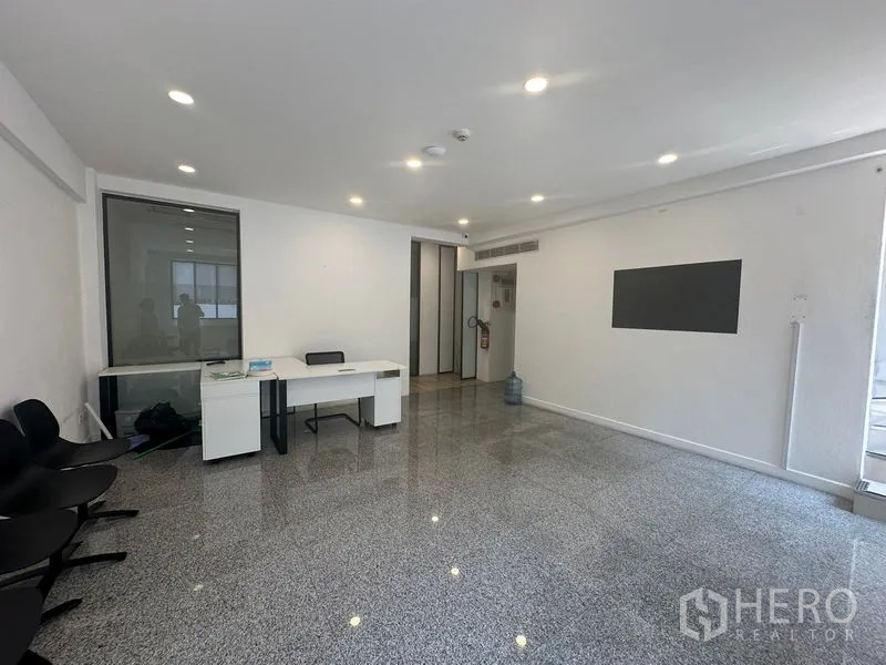 สำนักงานที่บ้าน ให้เช่าในBang Na, Bangkok - โถงต้อนรับสว่างพื้นเงา ผนังสีขาว โต๊ะทำงาน และไฟดาวน์ไลท์