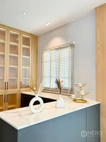 独立式住宅 出租或出售在Bang Phli, Samut Prakan - 當代備餐吧，雲石臺面、淺木收納櫃與百葉窗。
