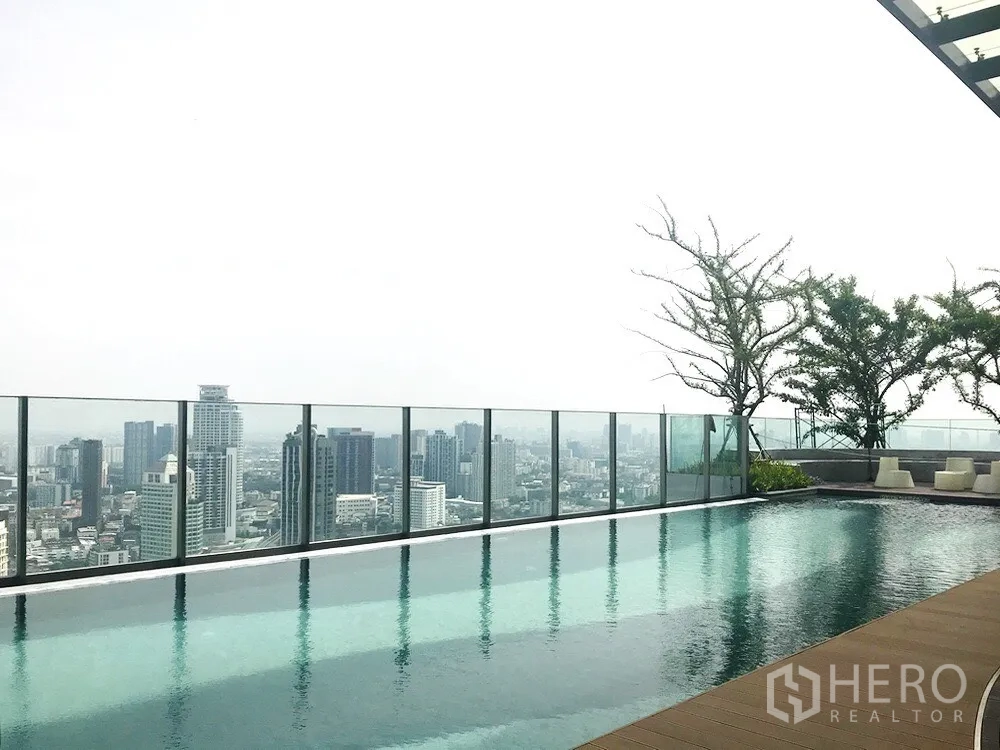 Condominium for sale in Khlong Toei, Bangkok - Rooftop infinity pool with glass railing and panoramic Bangkok skyline views.